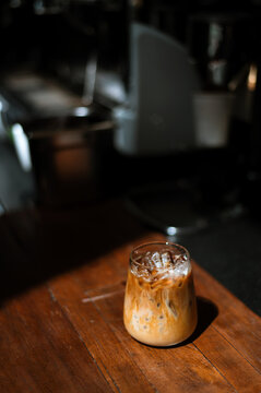 Ice coffee on a table with cream being poured into it showing the texture