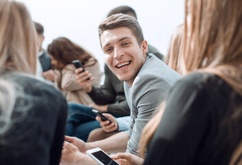 smiling guy sitting in a circle at a group meeting