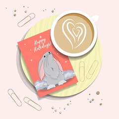 Morning post. A cup of coffee and a card with the symbol of 2023. Congratulatory Christmas card with a rabbit. View TOP. RABBIT