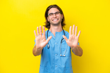 Young surgeon caucasian man isolated on yellow background counting ten with fingers