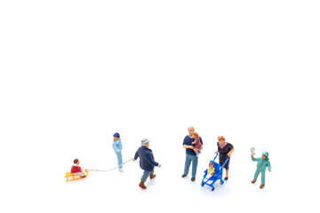 Miniature people Happy family ride a sleigh with white background, Christmas eve celebration...
