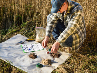 Closeup of agronomy specialist preparing soil samples for laboratory analysis outdoors....