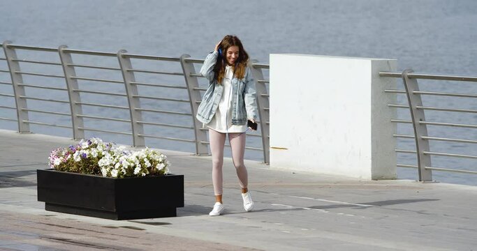 A happy girl received messages from a loved one - she is happy. She rereads the message again and dances with happiness.