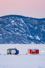 Colorful ice fishing huts on the frozen Saguenay fjord at sunset in La Baie, Quebec (Canada)