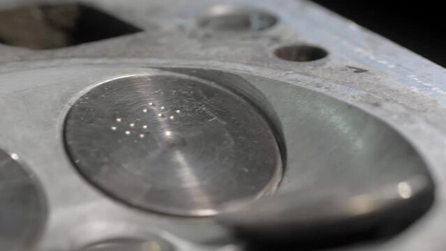 Old cylinder head block with valves. Close-up. Clean details. The movement of the camera on the slider is parallel to the details.