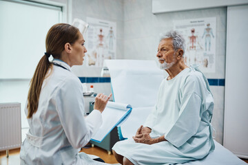 Senior patient talks to doctor during medical examination in hospital.