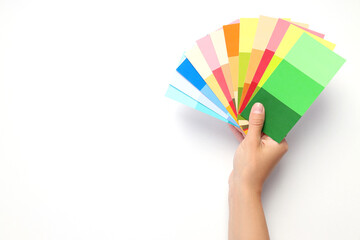Female hand holding color palettes on white background
