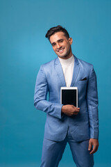 Young handsome man wearing business suit with tablet computer