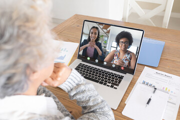 Senior caucasian woman making laptop video call with two diverse female colleagues