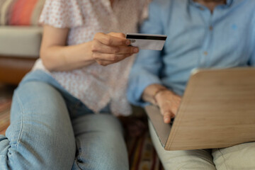 senior couple use credit card to shop from home