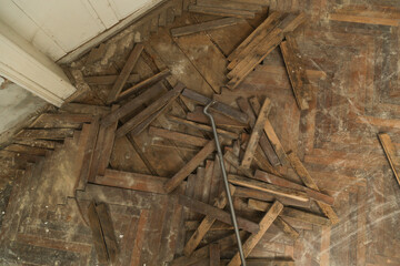 Home improvement. Removing old wooden parquet flooring using crowbar tool. Old wooden floor renovation.	