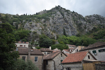 Fototapeta na wymiar roofs of houses and high mountains in Kotor, Montenegro