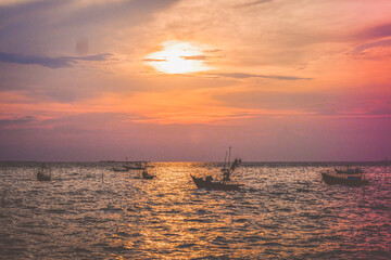 Fototapeta na wymiar Colorful Asian sunset panoramic view, and fishing boats in ocean
