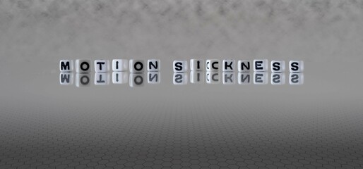motion sickness word or concept represented by black and white letter cubes on a grey horizon background stretching to infinity - obrazy, fototapety, plakaty
