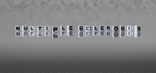 multiple sclerosis word or concept represented by black and white letter cubes on a grey horizon...