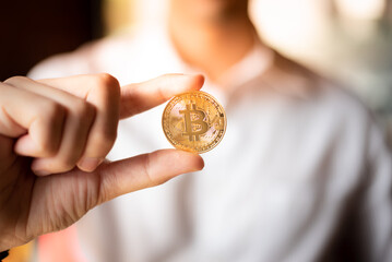 Young Asian business man holding bitcoin isolate. Crypto Currency coin in front of male white shirt background concept