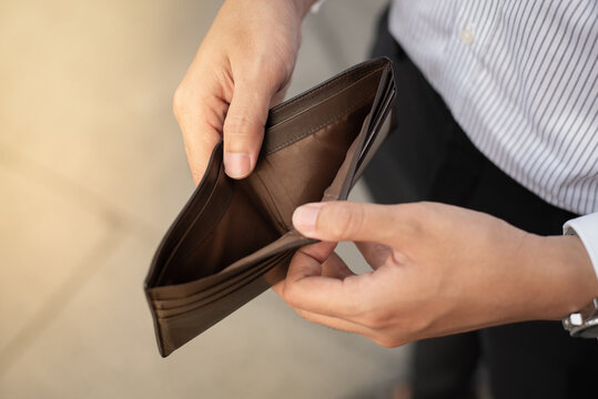 Businessman with unemployment and bankruptcy is characterized by his empty wallet, stress crisis, unemployed businessman waiting for a new job, recession situation and despair crisis concept.