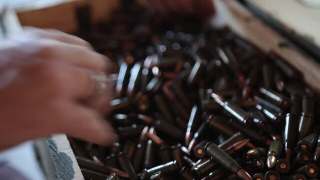 Hand taking ammo. Ammo taken by hand, ammunition for ak47 in 7,62 caliber, gun crime, war bullet weapon, bullet shells, shell gun ammunition, Close up shell gun ammunition.