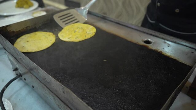 Cooking of Indian Methi paratha on tawa or frying pan for breakfast in Indian restaurant.