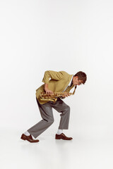 Fototapeta na wymiar Portrait of young man in stylish yellow jacket playing saxophone isolated over white background. Jazz festival