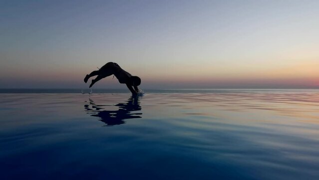 Beautiful woman relax in infinity swimming pool at luxury hotel spa enjoy golden sunset view of ocean mediterranean travel holiday resort. Female silhouette High quality slow motion 4k raw video