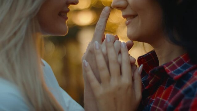 Lesbian couple two young women hold hands and touch each other's faces. Homosexual relationships in same-sex couple