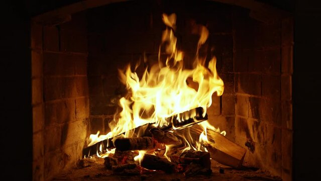 Burning Fire In The Fireplace. Slow Motion. A Looping Clip of a Fireplace with Medium Size Flames Winter and Christmas Holidays Concept. Cozy relaxing fireplace. UHD TV screen saver.