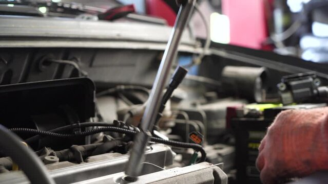 auto mechanic repairs car engine. auto repair shop. spark plug replacement