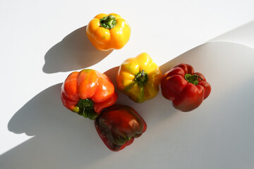 appetizing red and yellow peppers on a light background with beautiful shadows in daylight