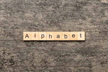 alphabet word written on wood block. alphabet text on cement table for your desing, concept