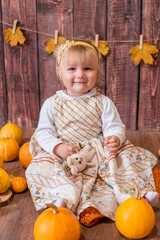 Little cute girl with orange pumpkins. Autumn mood. Halloween.