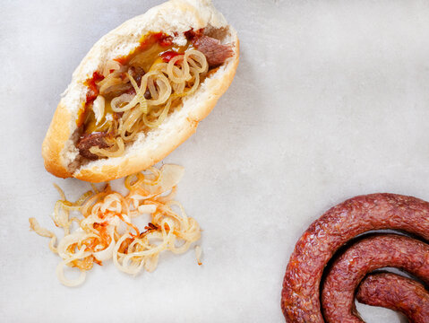 South African famous boerewors roll with fried onions and sauces. flat lay with ingredients and copy space