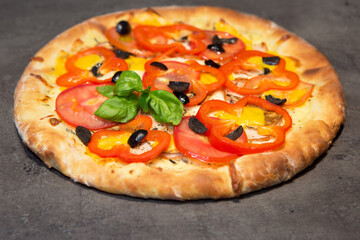 Appetizing pizza on a black concrete background. Top view.	