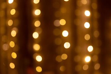 Golden bokeh lights on a dark background. magical light, overlay or lens flare effect