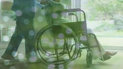 Animation of spots over asian nurse with woman in wheelchair