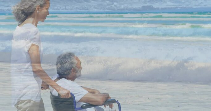 Animation of sea over biracial woman with man in wheelchair
