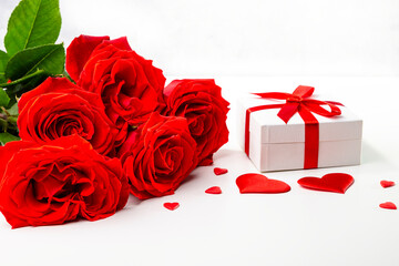 Gift box, rose flowers and decorative hearts on a white background