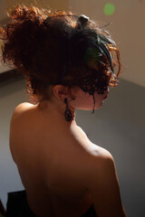Mysterious brunette girl in black mask with bare back. Model posing in studio