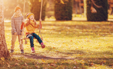 Couple of children playing in the autumnal park.