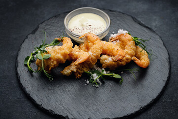 Tempura shrimp on a dark plate, on dark concrete