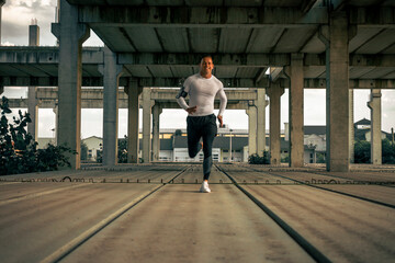 Runner in motion fast running. A sportsman have a workout outdoor. Concrete ambient. Sprinter.
