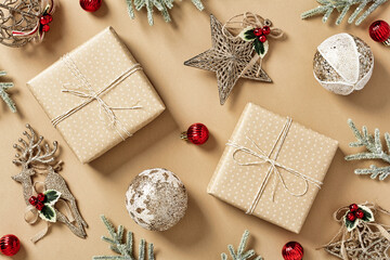 Craft Christmas gift boxes with fir branches, vintage decorations on beige background. Christmas holiday celebration, winter, New Year concept. Flat lay, top view.