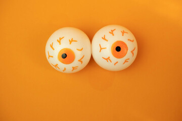 toy eyes on an orange background with a place for text, halloween concept