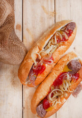 South African famous boerewors roll, juicy and topped with onions on a rustic surface