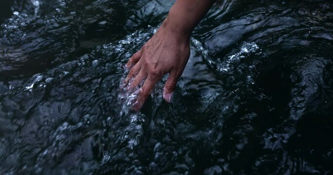 Stream water flowing on hand.
