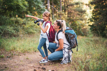 Mother and daughter using binoculars and enjoy hiking together.