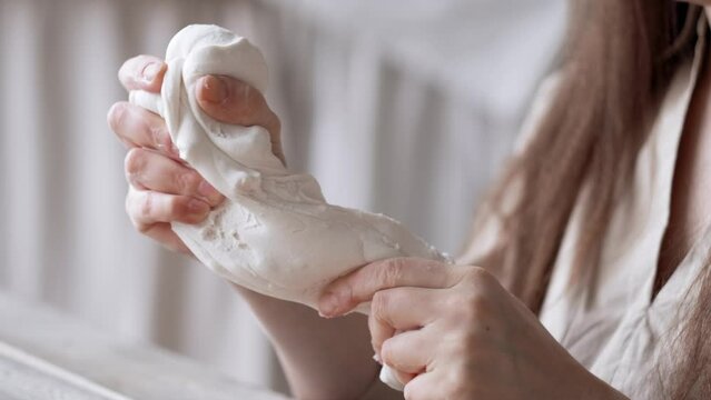 Handcraft woman master modeling cold porcelain, hands pull the clay dough in different directions, Girl sculpts from porcelain, hobby for the soul scandinavian and boho style interior decor