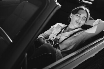 Woman road tripping by cabriolet and making photos on camera