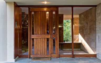 Contemporary residential building entrance natural wood door. Athens, Greece.