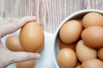 A Woman' hand is holding and show egg. Healthy food